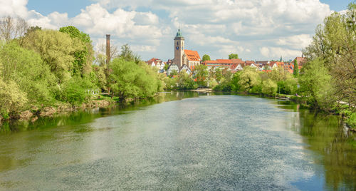 River amidst trees and buildings against sky