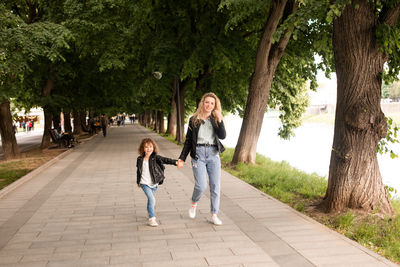 Full length of mother and daughter walking on tree