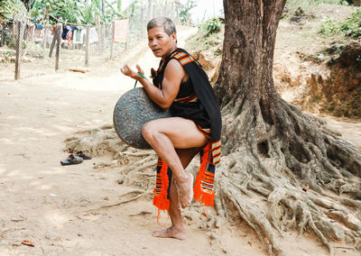 Full length of young woman sitting on rock