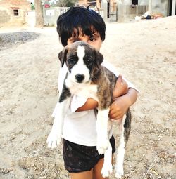 Portrait of woman with dog standing outdoors