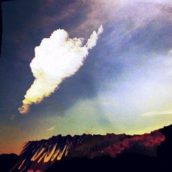 Scenic view of mountains against cloudy sky