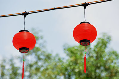 Low angle view of red lanterns hanging against sky