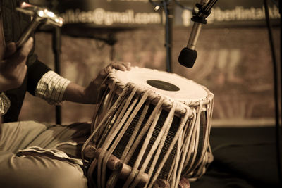 Midsection of man playing tabla at traditional ceremony