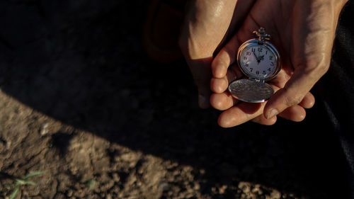 High angle view of woman hand holding clock