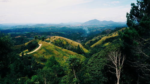 Aerial view of green landscape and mountains against sky