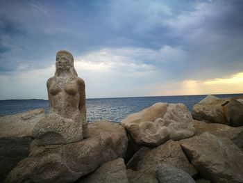 Scenic view of rocks on beach against sky