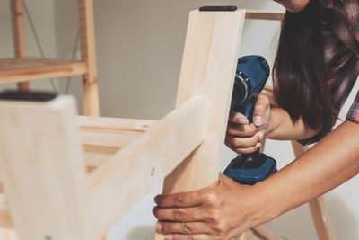 Midsection of woman working on wood