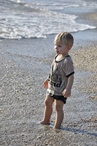 Portrait of cute boy standing at beach