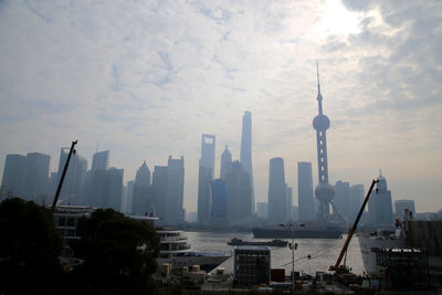 Skyscrapers by huangpu river against sky