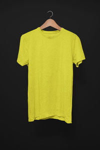 Yellow bell hanging against black background
