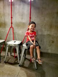 Portrait of boy sitting on swing at playground