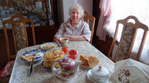 Woman sitting on table at home