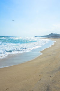 View of calm beach against blue sky