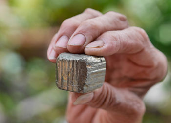 Close-up of human hand holding rusty metal