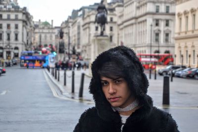 Portrait of teenage boy standing in city