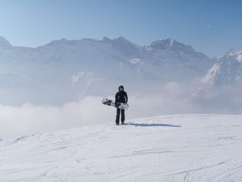 Rear view of woman standing on snow covered landscape