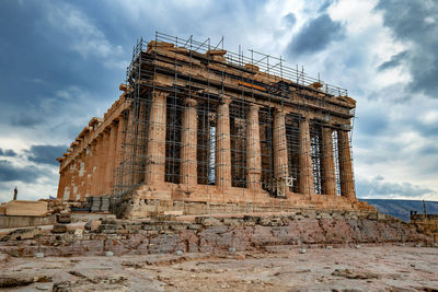 Low angle view of old temple against cloudy sky