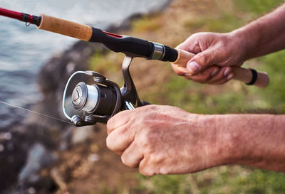 Cropped hands holding fishing rod