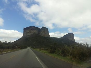 Road by mountain against sky