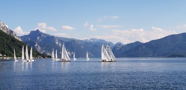 Sailboats in sea against sky