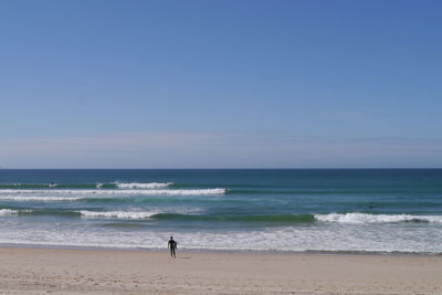 Man standing on beach against clear sky