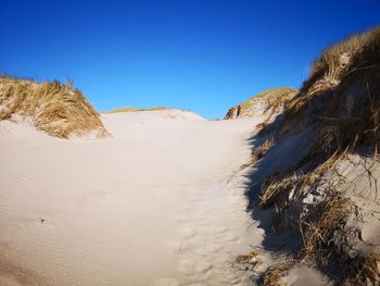 Panoramic view of desert against clear blue sky