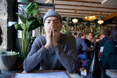 Portrait of young couple sitting on table at restaurant