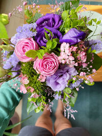 Low section of person standing by purple flowering plants