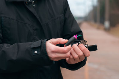 Midsection of man holding mobile phone