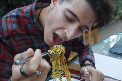 Man eating noodles at restaurant