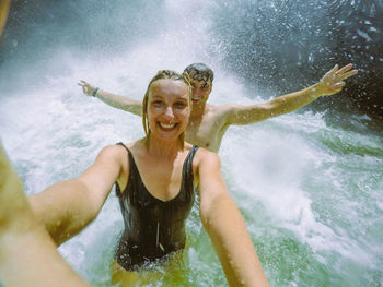Portrait of couple enjoying at waterfall