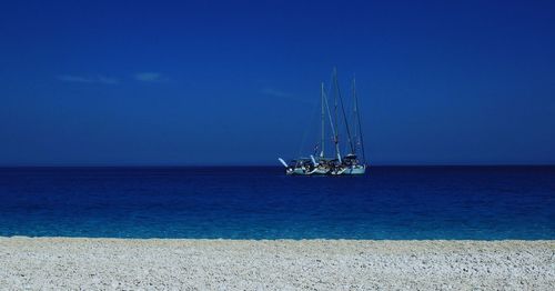 Sailboat in sea against blue sky