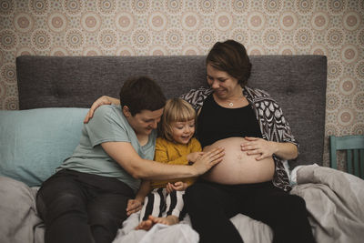 Mothers and daughter touching pregnant belly