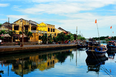 Boats moored in water against sky