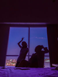 Silhouette couple against window in bedroom