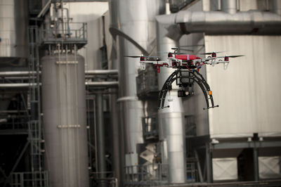 Professional red drone flying around in the outdoor of a factory.