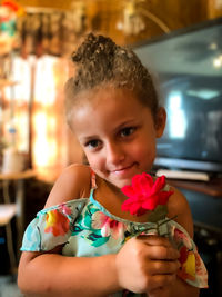 Portrait of girl holding red flower