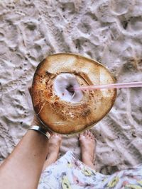 Low section of person having coconut water at beach