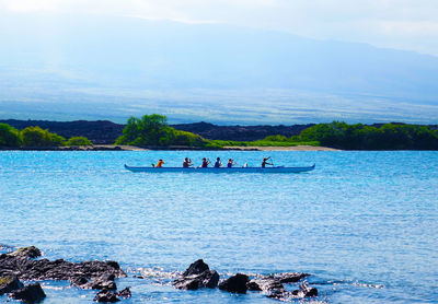 People enjoying in sea against sky