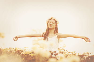 Young woman with arms outstretched against white background
