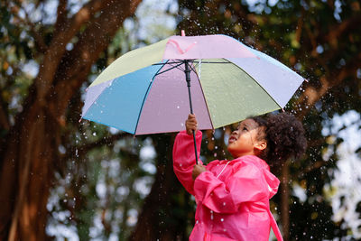 Cute girl holding umbrella outdoors