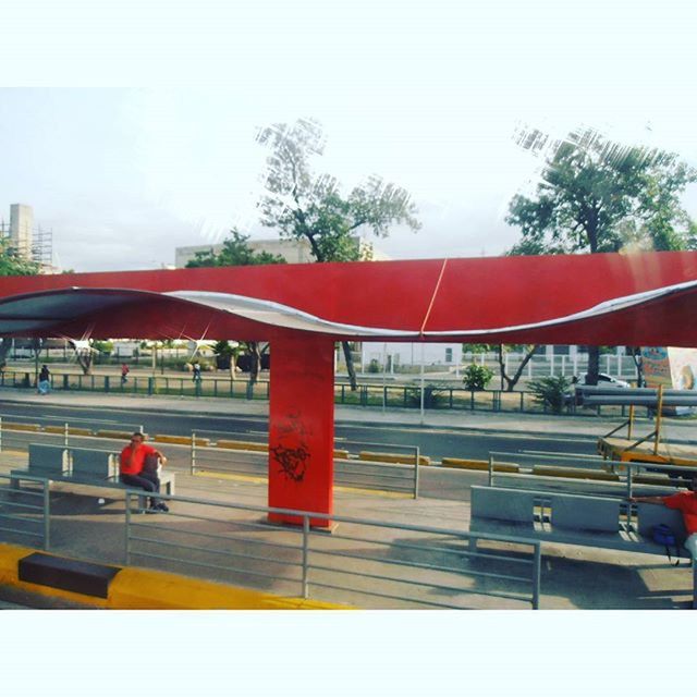 red, clear sky, built structure, architecture, tree, building exterior, chair, empty, railing, city, day, absence, bench, transfer print, auto post production filter, sky, outdoors, table, seat, incidental people