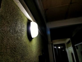 Low angle view of illuminated lamp hanging on ceiling in building