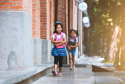 Full length of girl standing against building