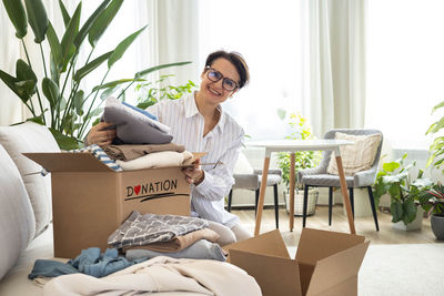 Young woman using laptop while sitting on sofa at home