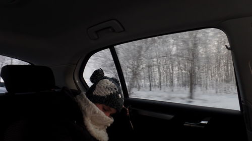 Reflection of man on side-view mirror of car