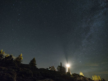 Illuminated lighthouse against sky at night