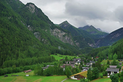 Scenic view of green landscape and mountains against sky