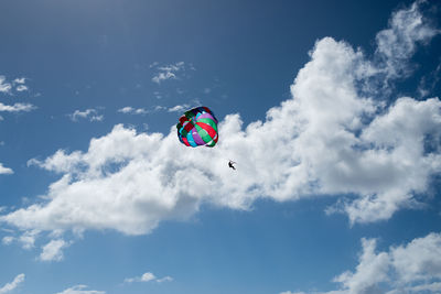 Low angle view of man parasailing against sky