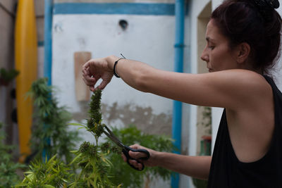 Side view of woman holding plants